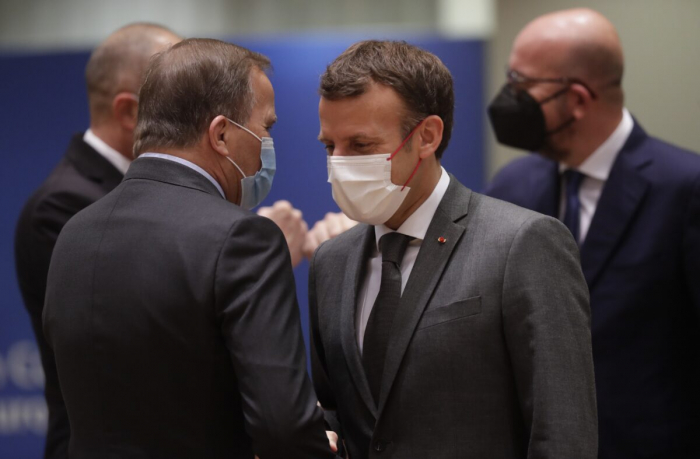 Президент Франции Эммануэль Макрон (справа) беседует с премьер-министром Швеции Стефаном Лофвеном во время саммита ЕС в здании Европейского совета в Брюсселе 25 июня 2021 г.